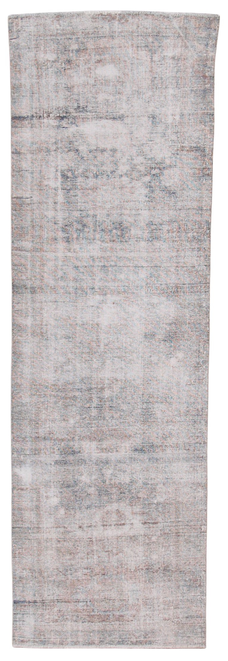A rectangular area rug with a distressed, vintage-style pattern in muted shades of gray, beige, and off-white.