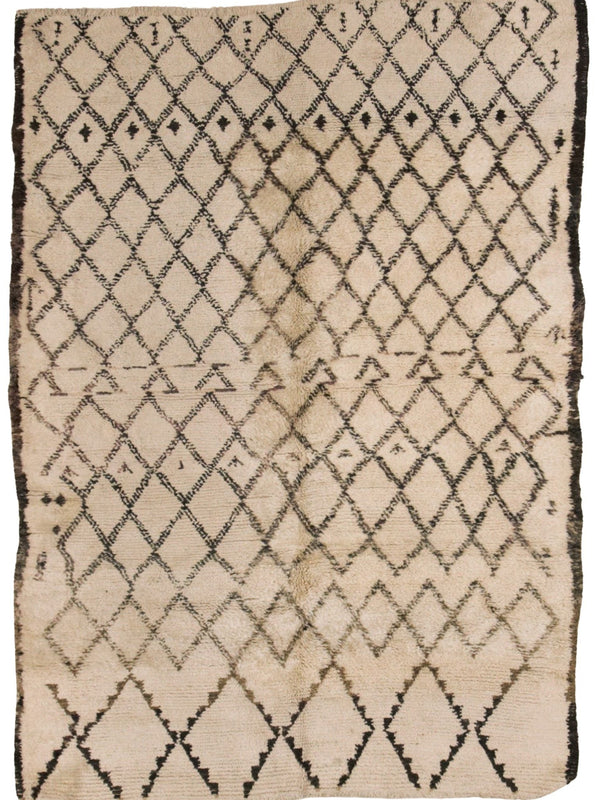 A square beige textile rug or mat with a black diamond lattice pattern and a dark fringe around the edges, photographed flat against a white background.