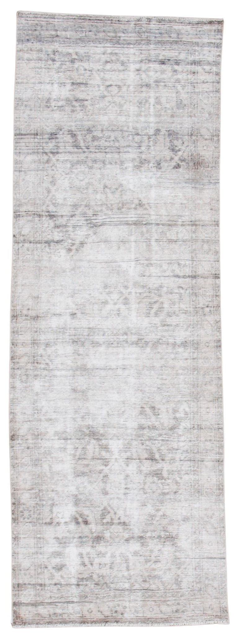 A rectangular area rug with a distressed, vintage-style pattern in shades of gray, beige, and off-white.